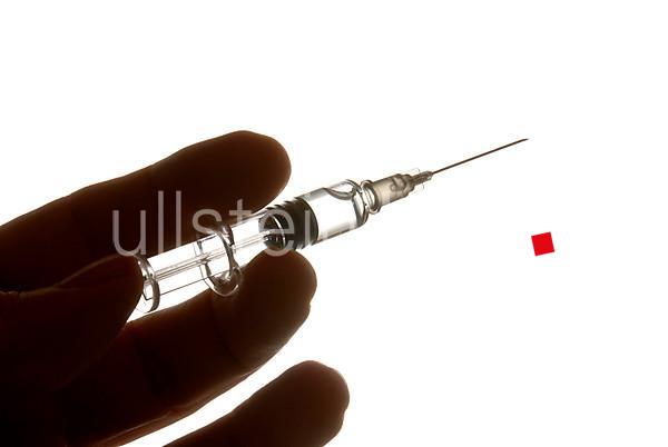 Hand with syringe, symbolic image for flu vaccination